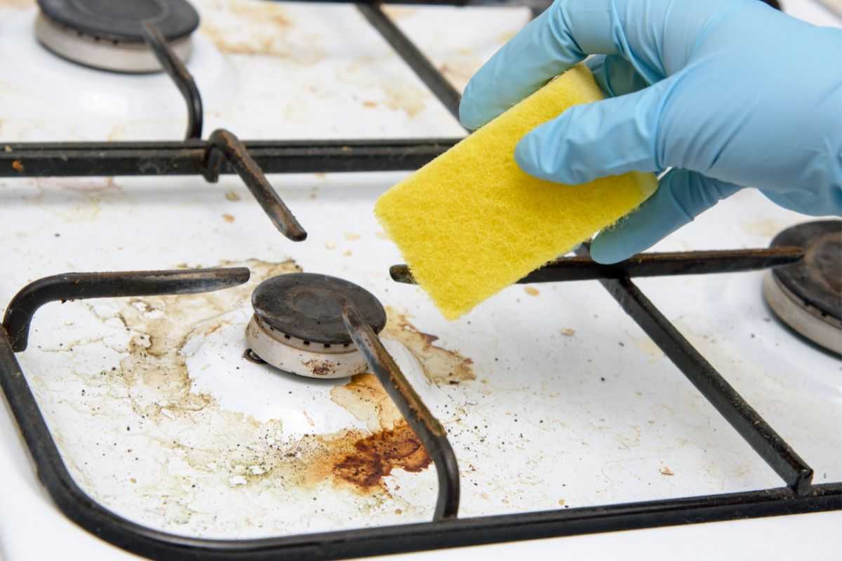 mano che mantiene spugna per pulire cucina