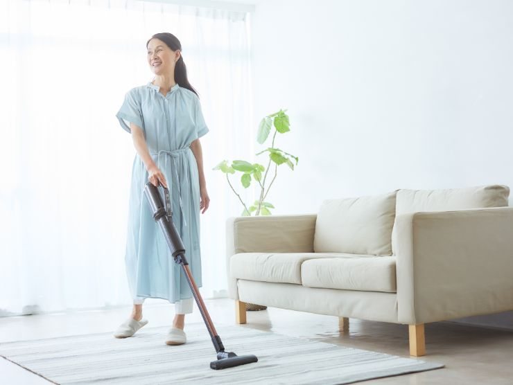 donna che passa scopa elettrica in salotto