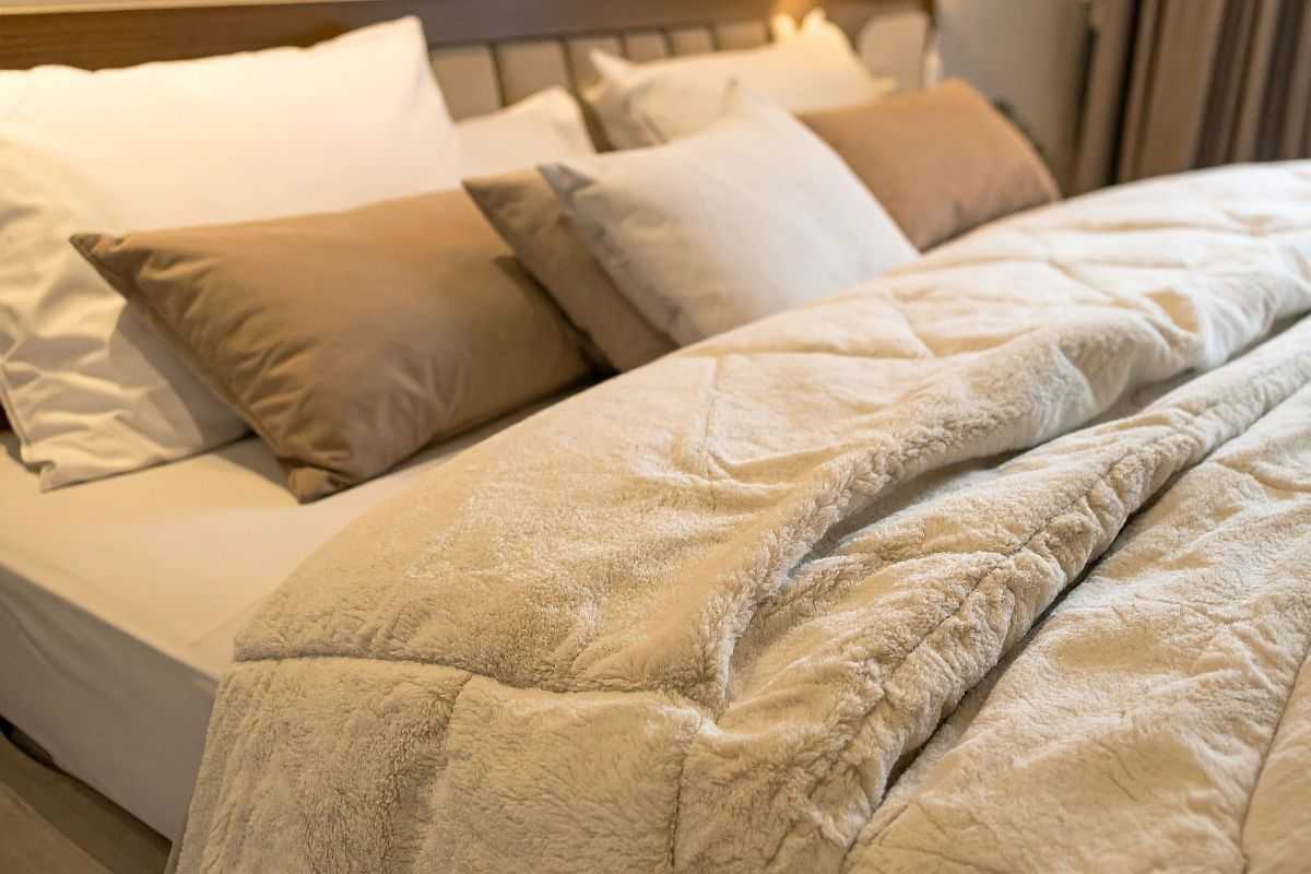 letto con lenzuola e trapunta